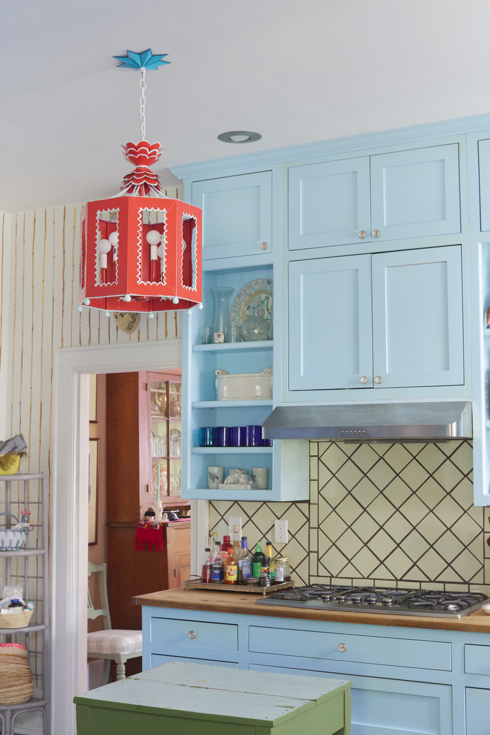 Kitchen with blue cabinets and a red lantern pendant light.
