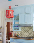 Kitchen with blue cabinets and a red lantern pendant light.