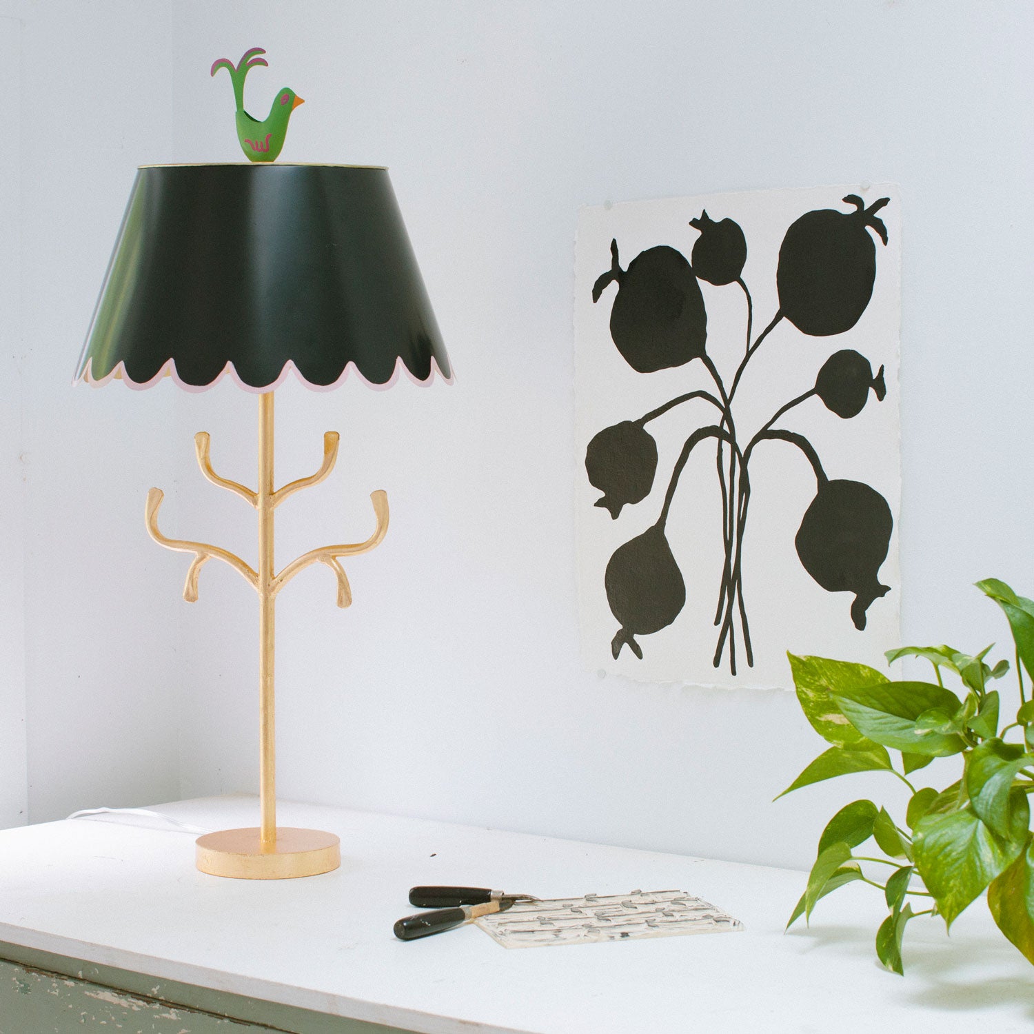 gold iron lamp with branches, black scalloped shade and green bird